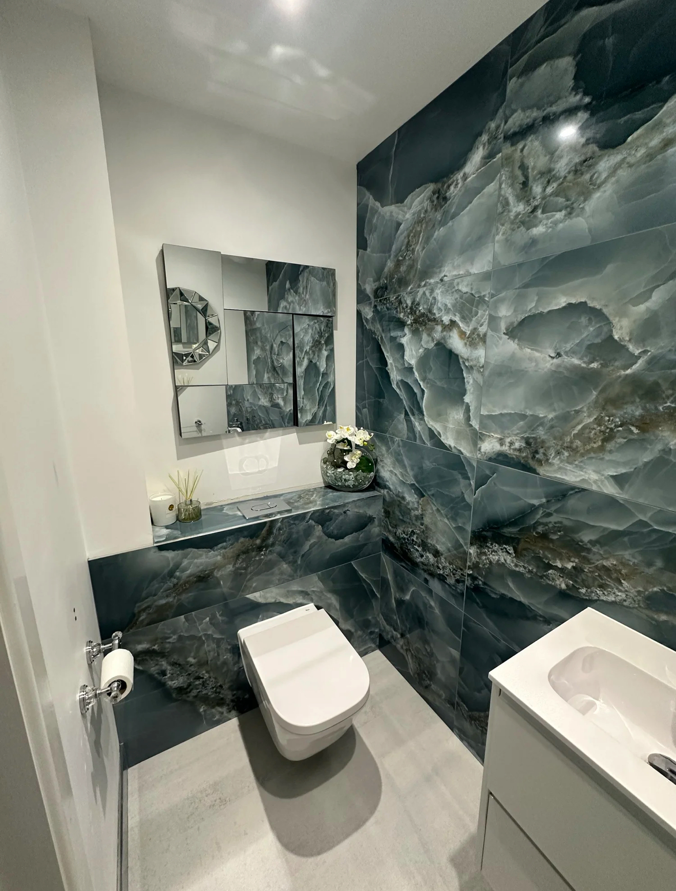 Cloakroom with dramatic blue onyx-effect feature tiles and wall-hung WC — Haslemere bathroom refurbishment
